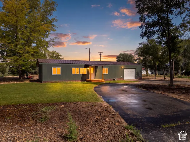 Single-level residence with a metal roof and dark green siding