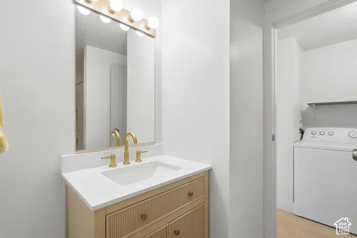 Vanity with gold-toned fixtures, a white countertop, and a rectangular sink