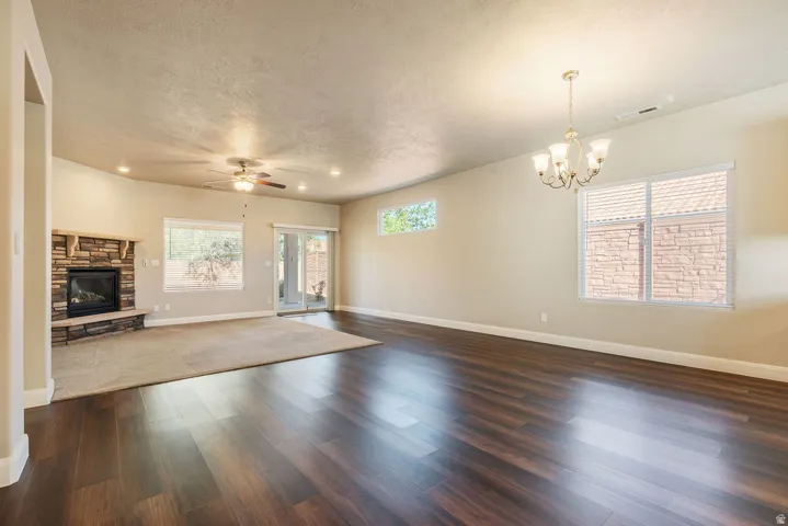 Spacious interior featuring wood-finish flooring, a stone-clad fireplace, and sliding glass doors