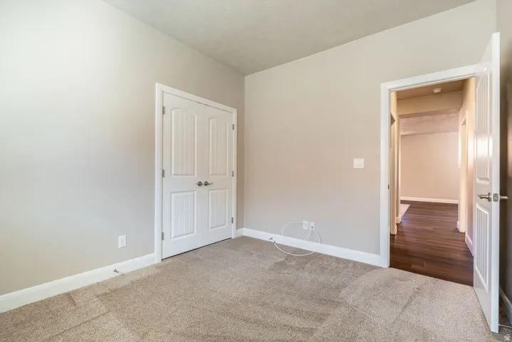Carpeted flooring, neutral wall paint, white trim, and white paneled doors