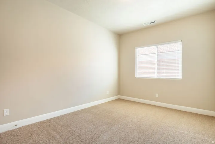Neutral-toned walls complement the carpeted flooring