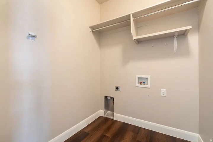 Wall-mounted shelving with hanging rod, wood-finish flooring, and crisp white trim