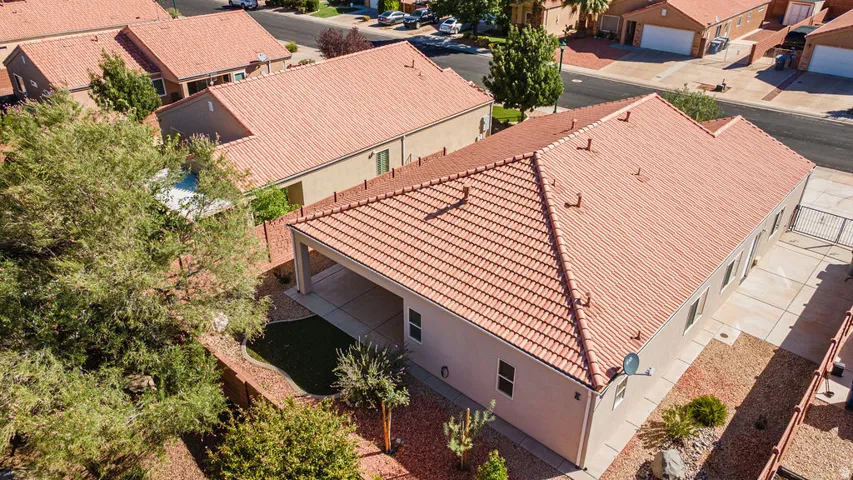 Tile roof, covered patio, artificial turf area, mature landscaping, paved side yard