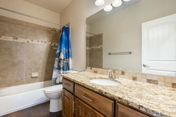 Bathroom featuring a vanity with a granite countertop, undermount sink, and wood-finish cabinetry