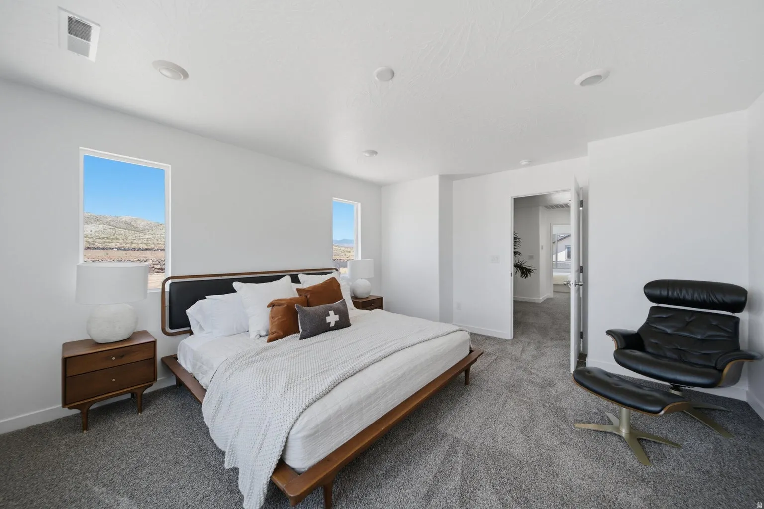 Plush carpeting, recessed lighting, and bright white walls