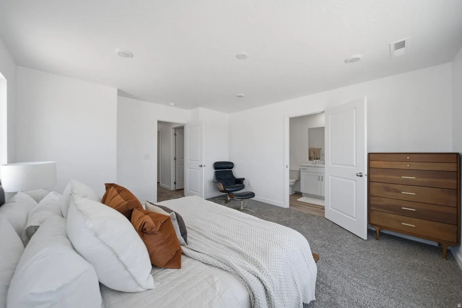 White walls with recessed lighting and gray carpeting