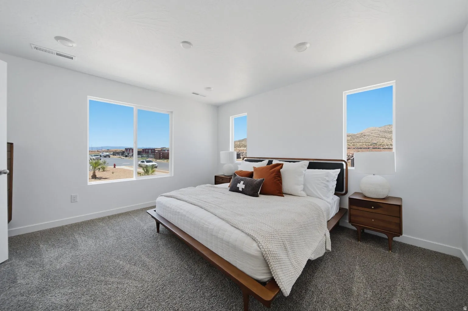 White interior walls with recessed lighting and gray carpeting