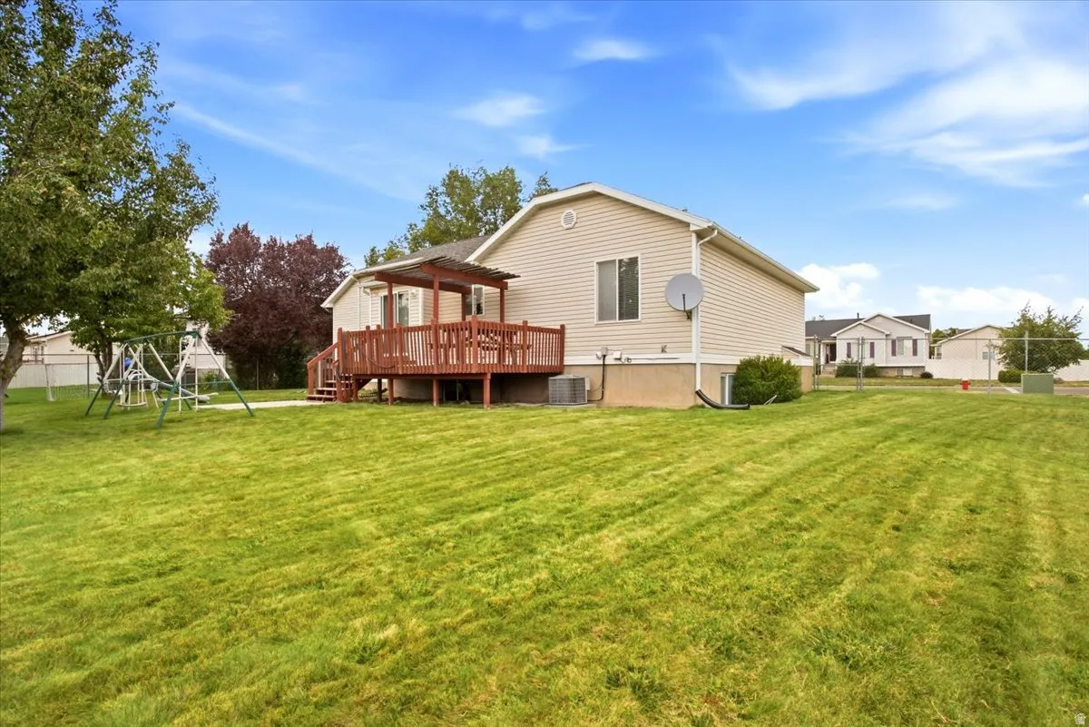 Expansive green lawn with mature trees and a fenced perimeter