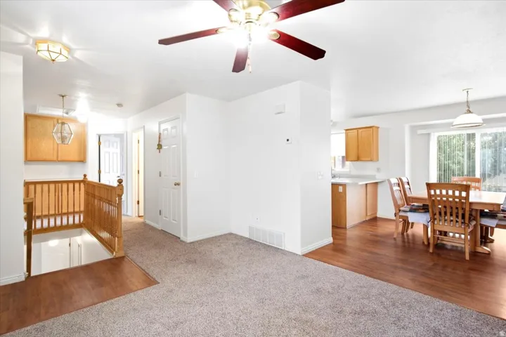 Wood-finish flooring, sliding glass door, overhead lighting, wood railing, wood cabinetry