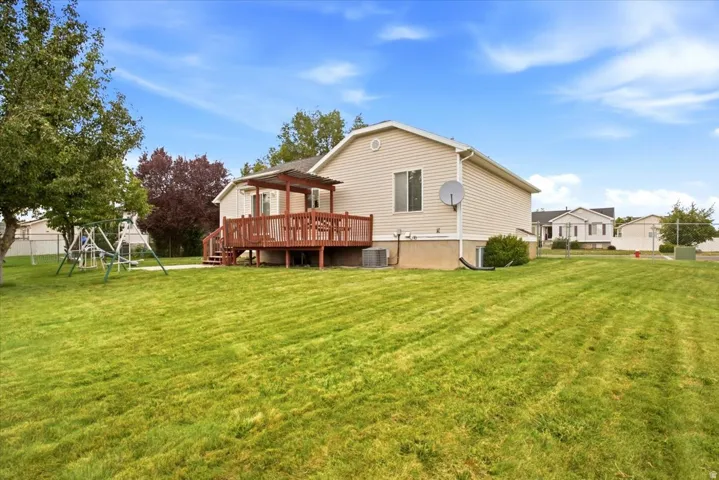 Expansive green lawn with mature trees and a fenced perimeter