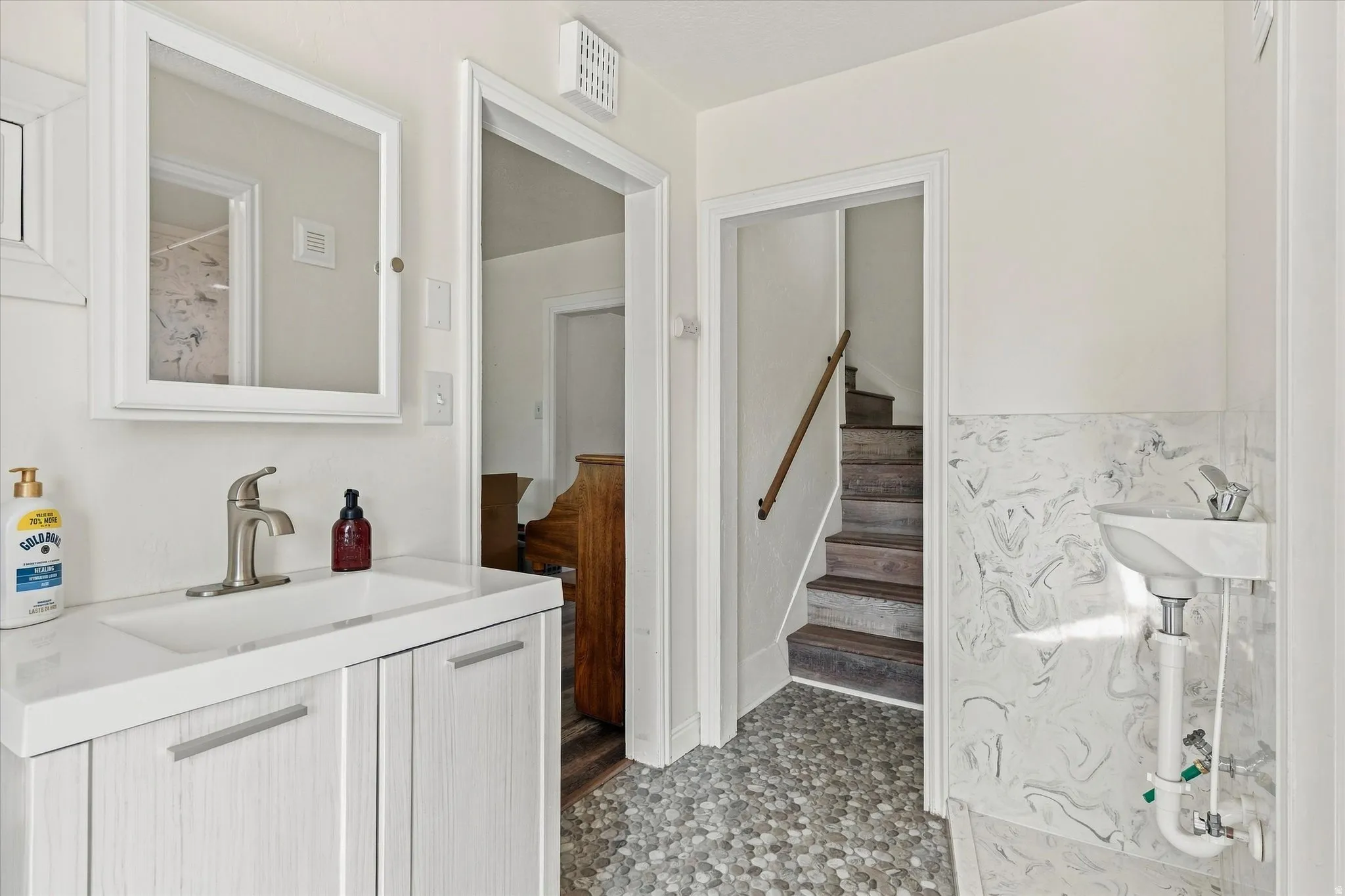 Bathroom with a white vanity, integrated sink, and brushed nickel faucet