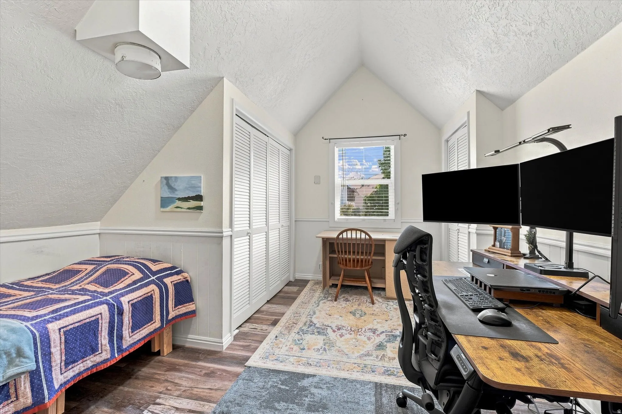 Vaulted ceiling featuring a window with blinds, wood-finish flooring, and white bifold closet doors