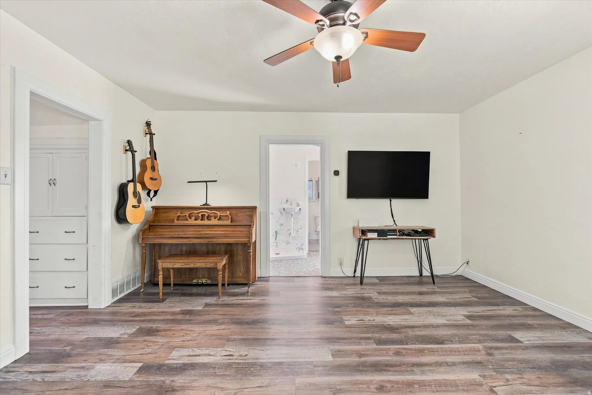 Wood-finish flooring, ceiling fan with integrated lighting, and built-in cabinetry
