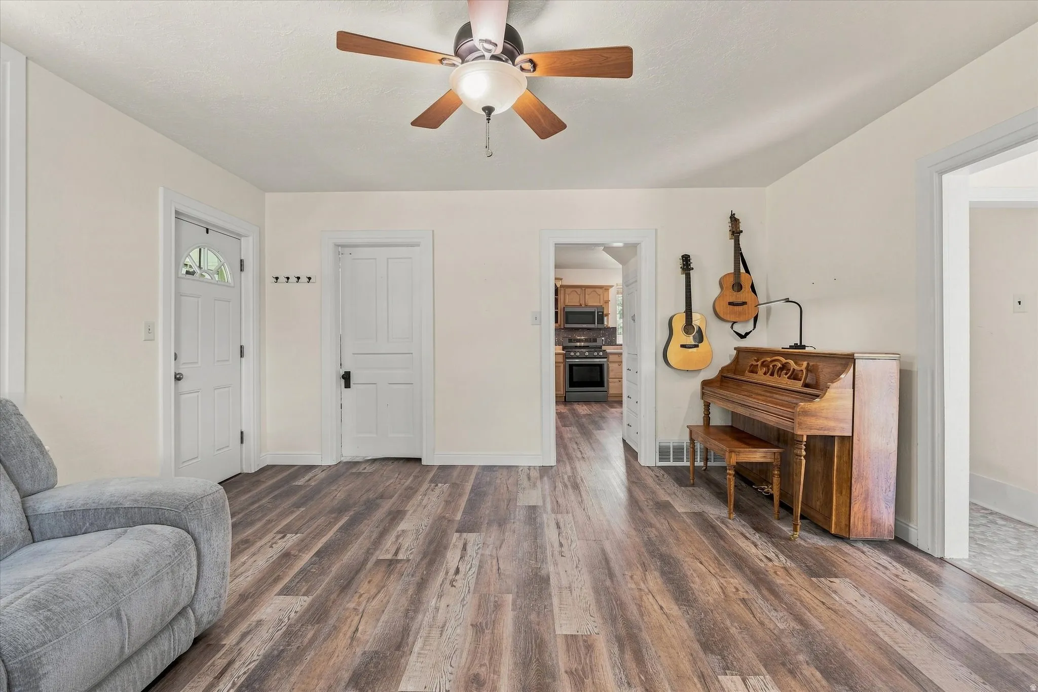 Wood-finish flooring throughout, complemented by a ceiling fan with integrated lighting