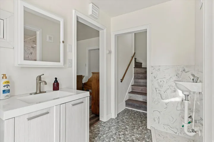 Bathroom with a white vanity, integrated sink, and brushed nickel faucet
