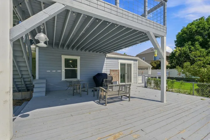 Multi-level decking with a covered patio area, exterior siding, and a sliding glass door