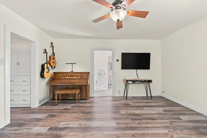 Wood-finish flooring, ceiling fan with integrated lighting, and built-in cabinetry