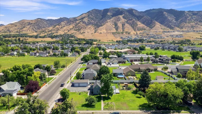 Expansive neighborhood featuring a mix of residential structures, mature trees, and a paved road