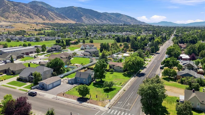 Expansive mountain backdrop with a wide residential street, mature trees, and surrounding green spaces