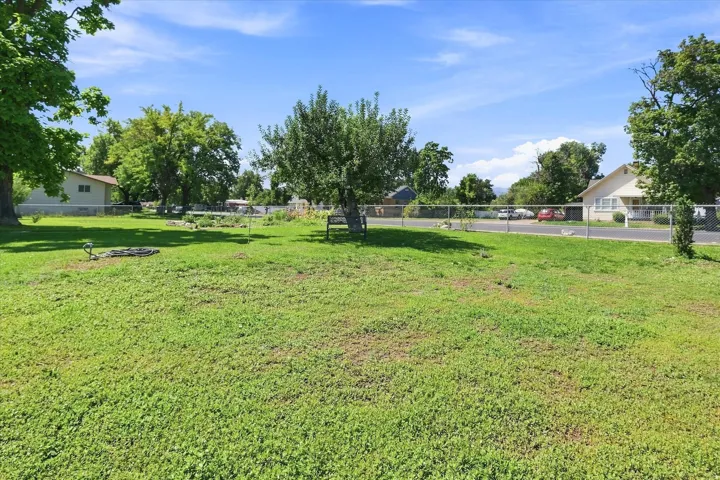 Expansive green space featuring a chain-link fence