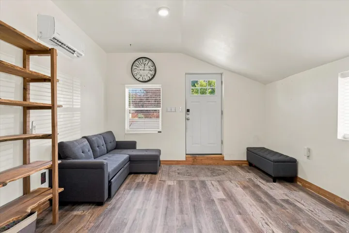 Wood-finish flooring, white walls, and a mini-split HVAC system