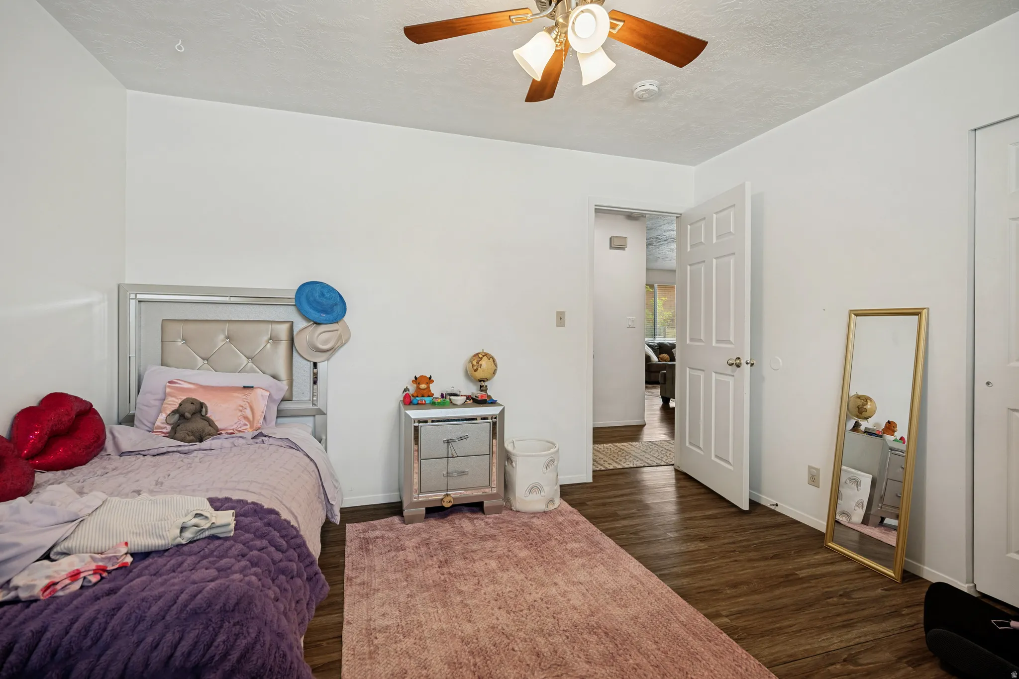 6711 - Main level bedroom 2. Wood-finish flooring, white walls, and a ceiling fan with integrated lighting