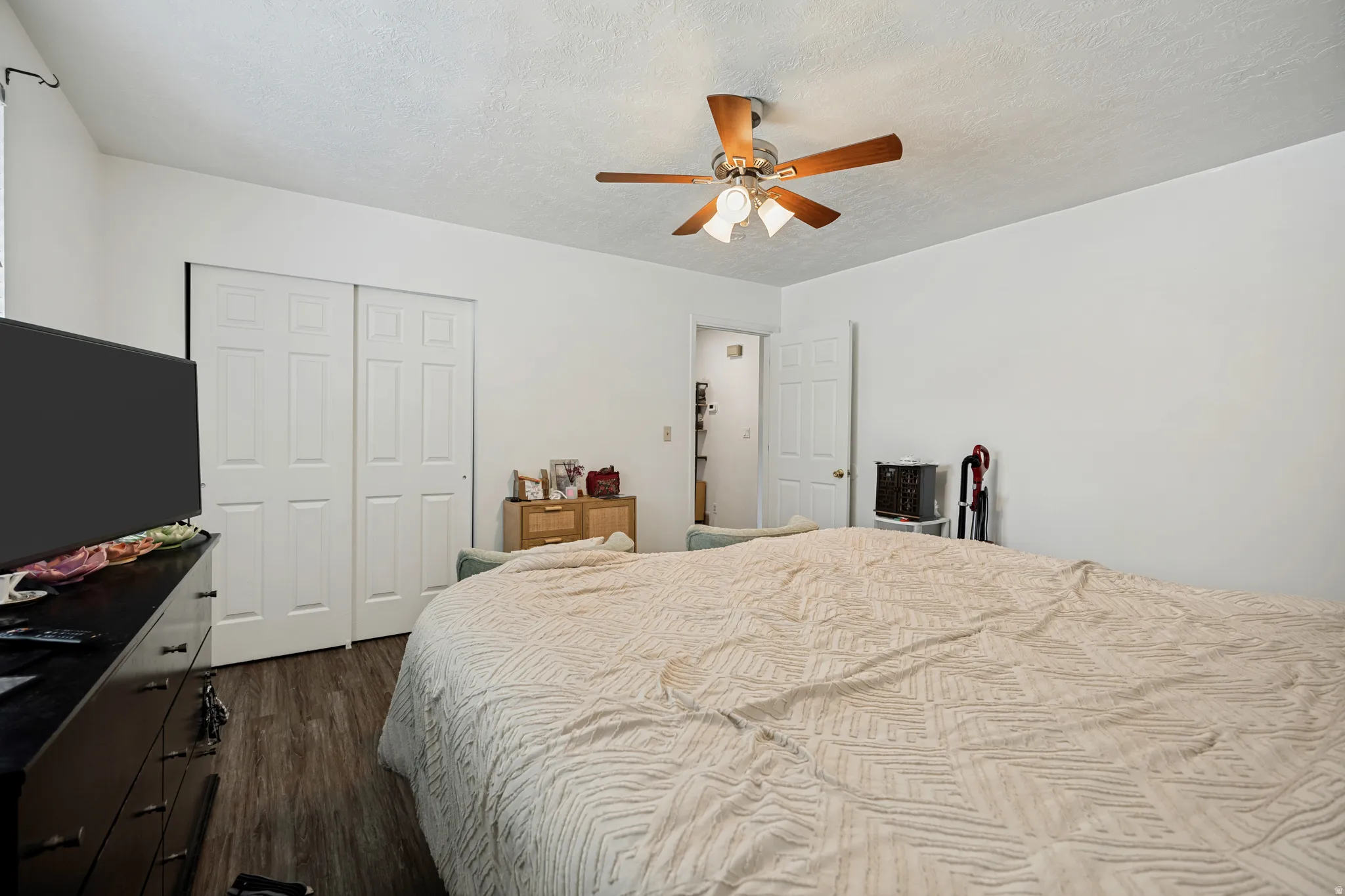 6711 - Main level Bedroom 1. Wood-finish flooring, white walls, and a ceiling fan