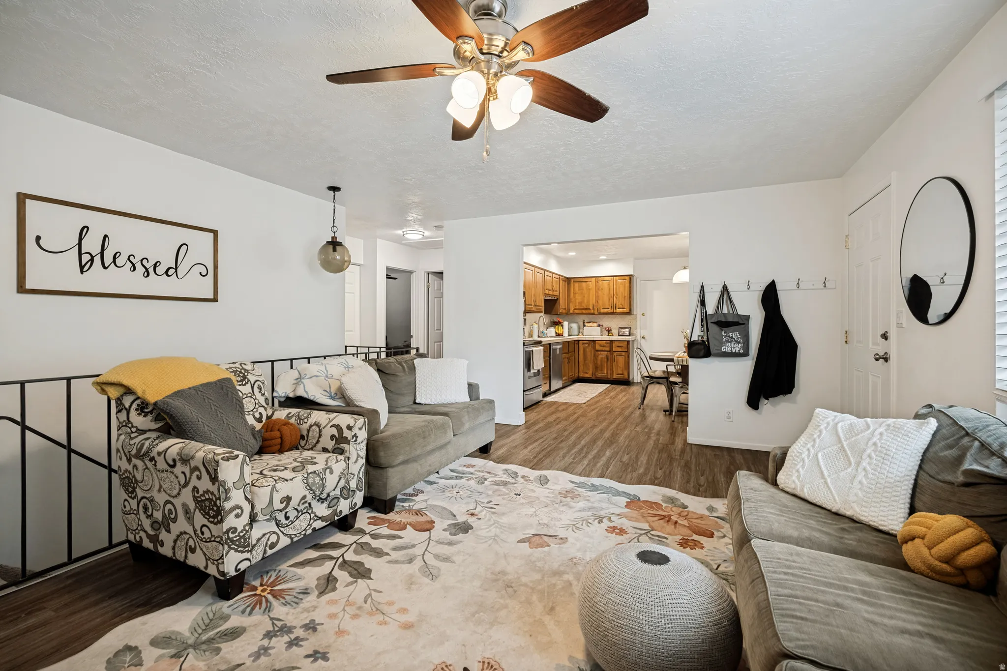 6711 - Wood-finish flooring throughout, ceiling fan with integrated lighting, and a glass orb pendant light