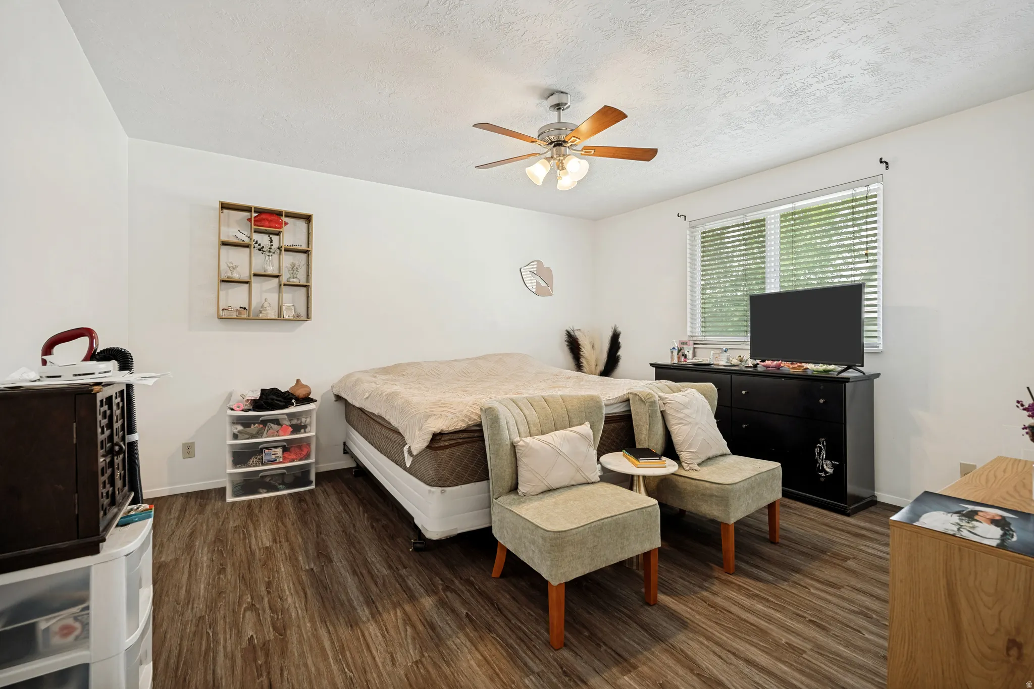 6711 - Main Level Bedroom1. Wood-finish flooring, ceiling fan, white walls, and a window with blinds
