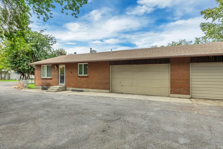 Unit 6711 Brick exterior with multiple garage doors and an asphalt driveway