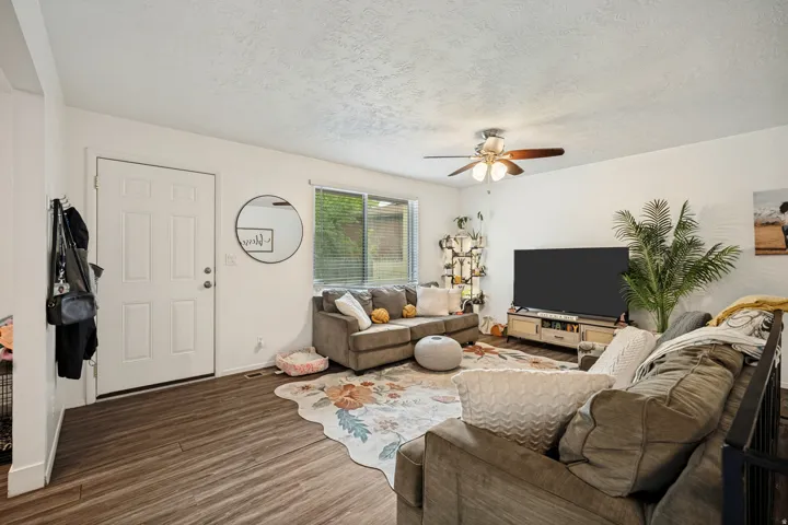 6711 - Wood-finish flooring, white walls, and a ceiling fan with integrated lighting