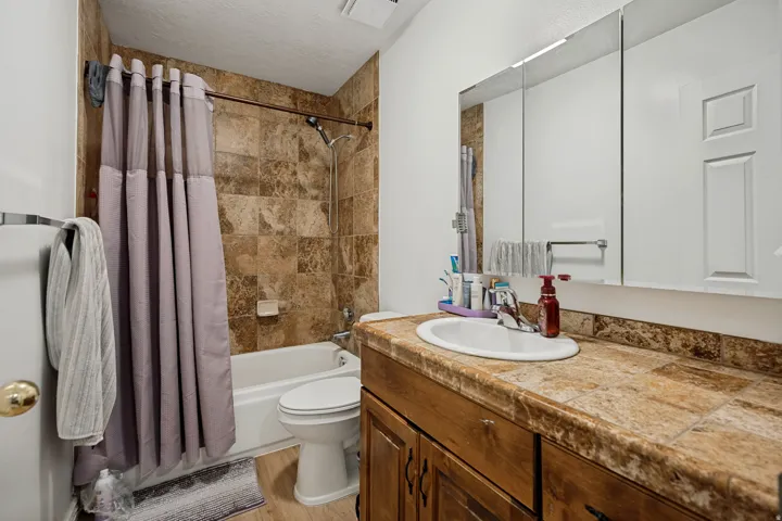6711 -Main level bathroom.  Built-in wood-finish vanity with an integrated sink and tiled countertop