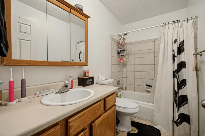 6709 - Main level bathroom. Wood-finish vanity with an integrated sink and laminate countertop