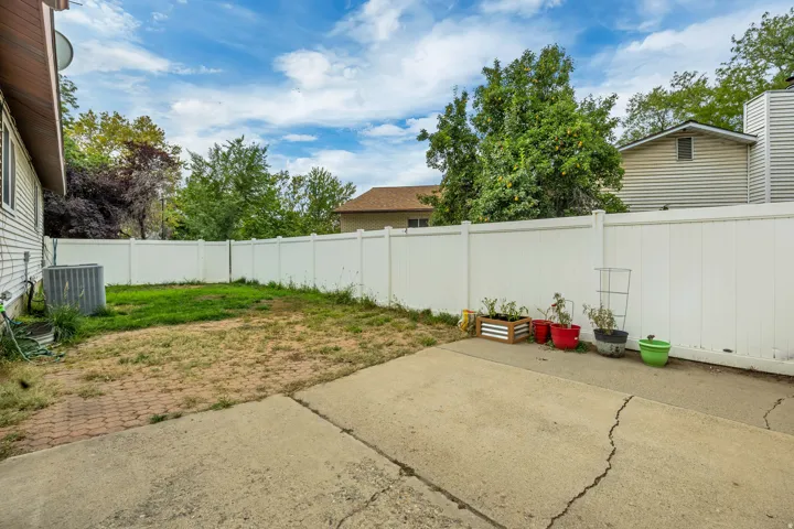 6711 - Private outdoor space featuring a white privacy fence, concrete patio, and a grass area