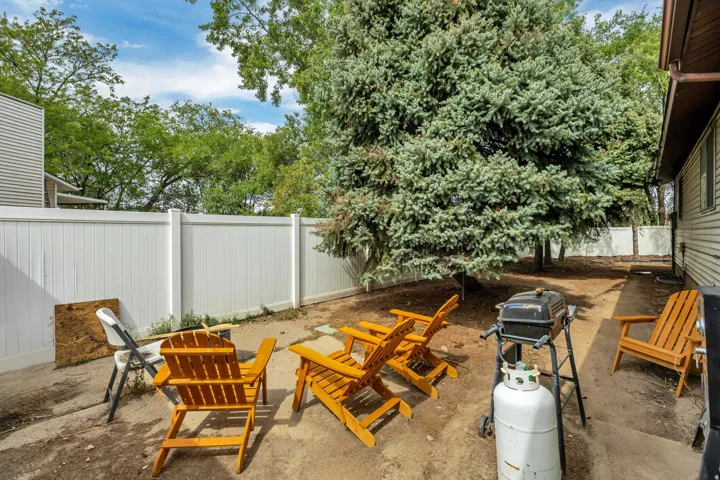 6709 - Enclosed outdoor area featuring a white privacy fence and mature evergreen trees
