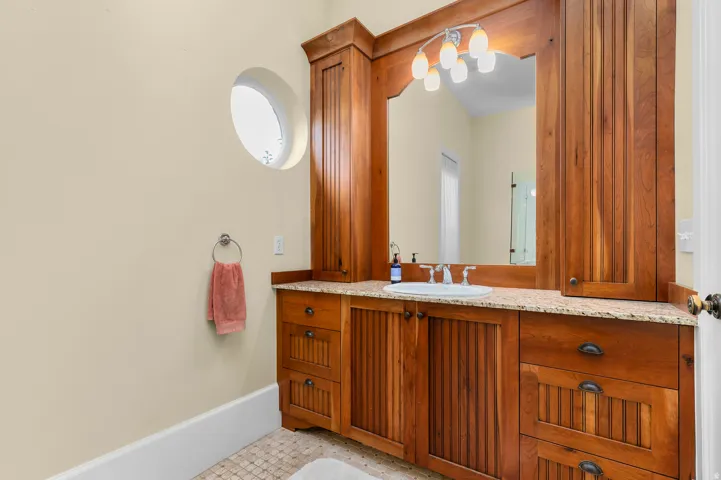 Custom wood cabinetry with integrated storage, granite countertop, and undermount sink