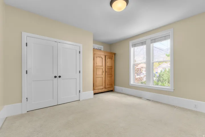 Cream-colored walls with white trim, light beige carpet flooring, and a flush mount ceiling light fixture