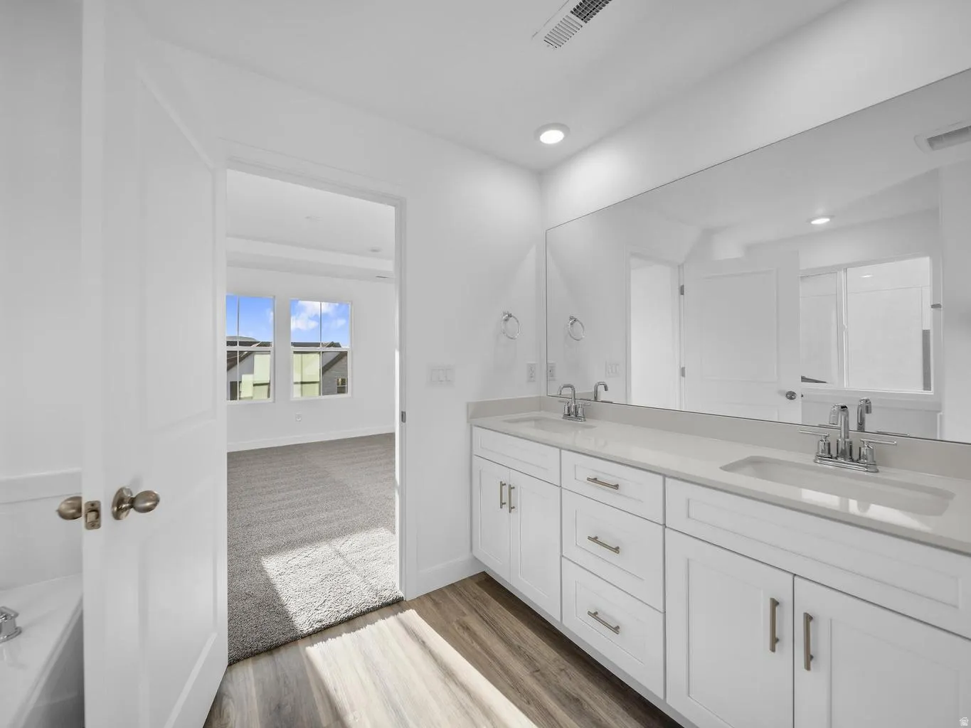 Dual vanity with undermount sinks, chrome fixtures, and light-toned countertops