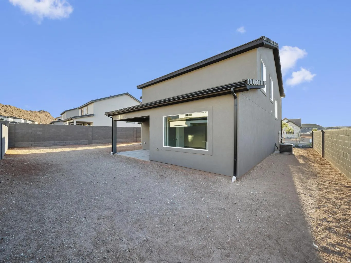 Rear exterior featuring a covered patio, stucco siding, and a block wall perimeter