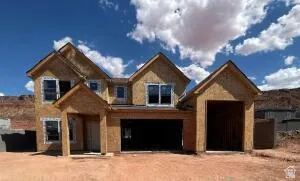 Multi-story residence under construction featuring a three-car garage, multiple gabled rooflines, and a covered entry