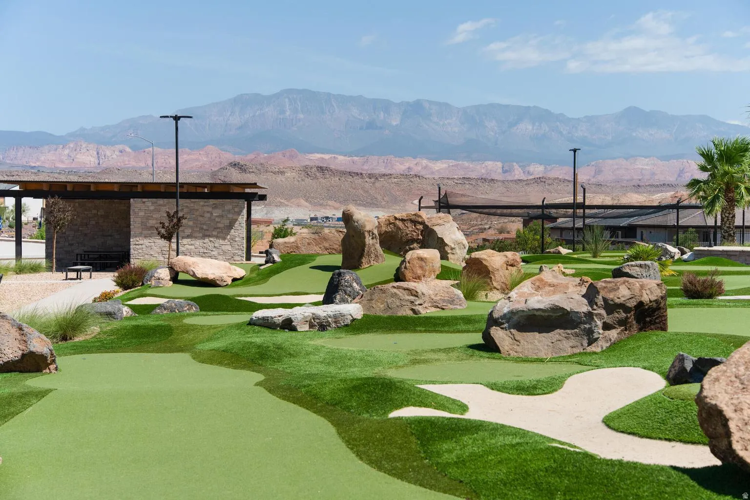 Miniature golf course with integrated sand traps and large rock landscaping