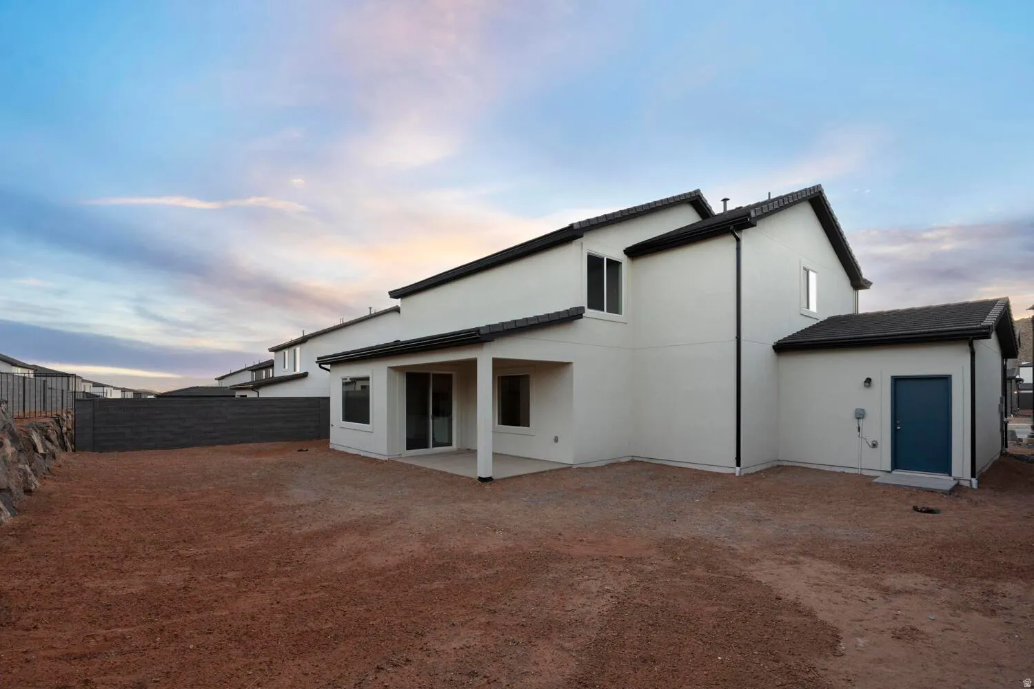 Modern stucco exterior with dark trim and a covered patio