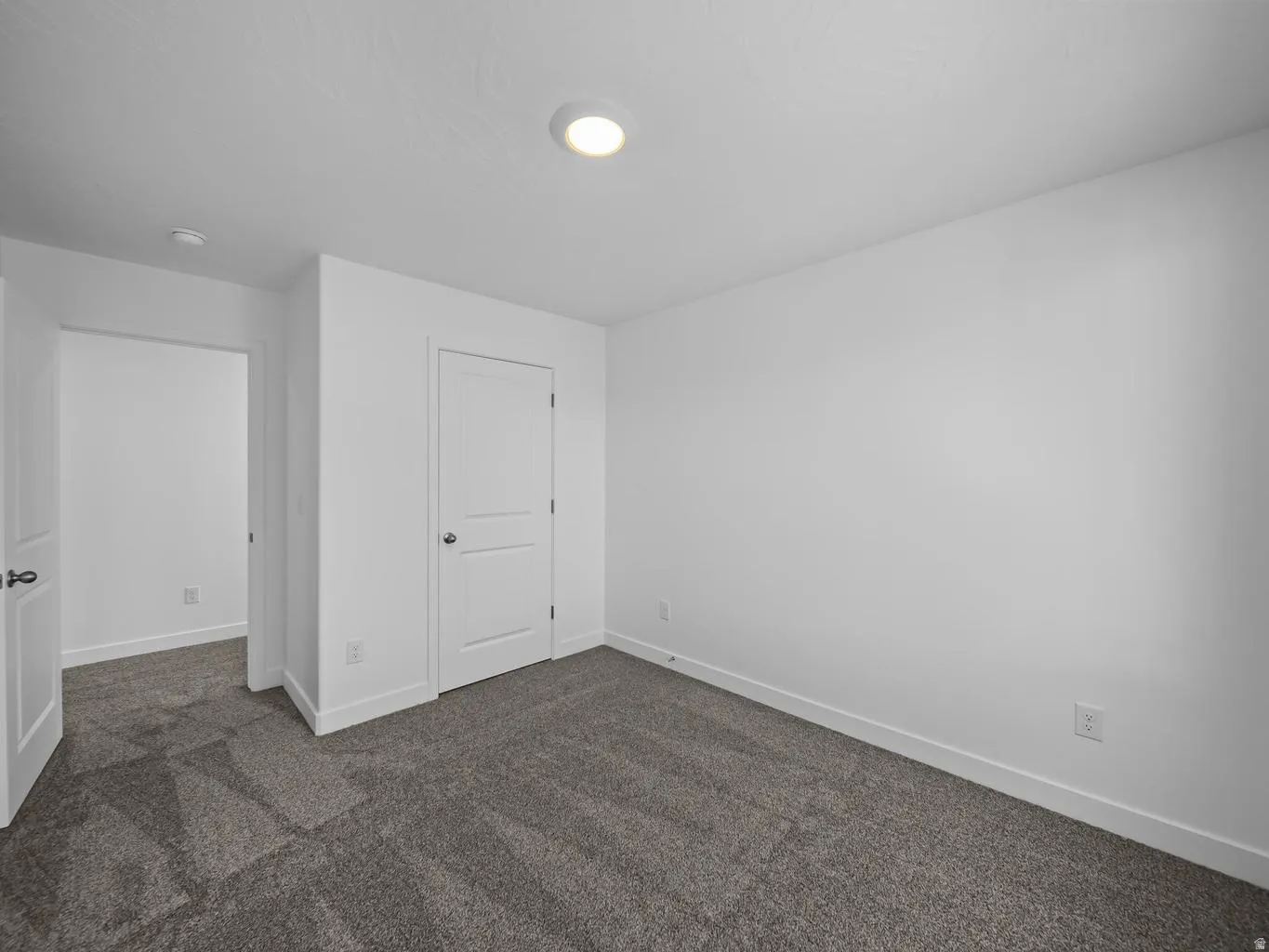 Neutral-toned wall-to-wall carpeting, white interior doors, and recessed ceiling lighting