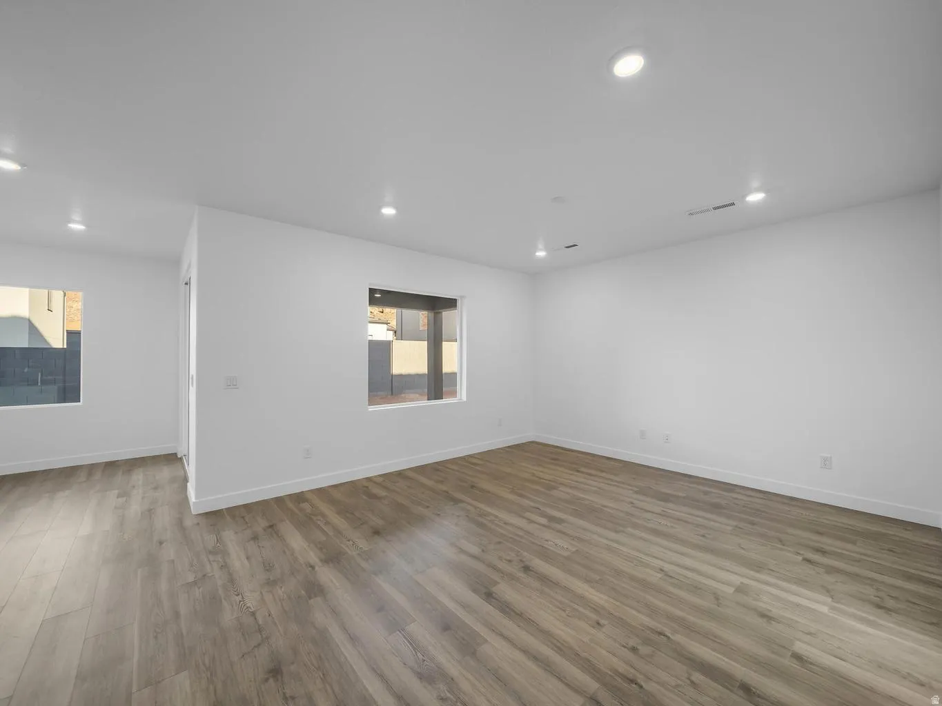 Wood-finish flooring, recessed lighting, and multiple windows
