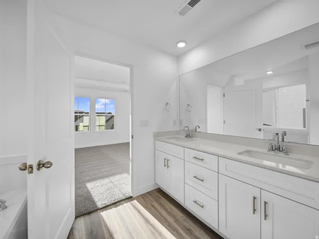Dual vanity with undermount sinks, chrome fixtures, and light-toned countertops