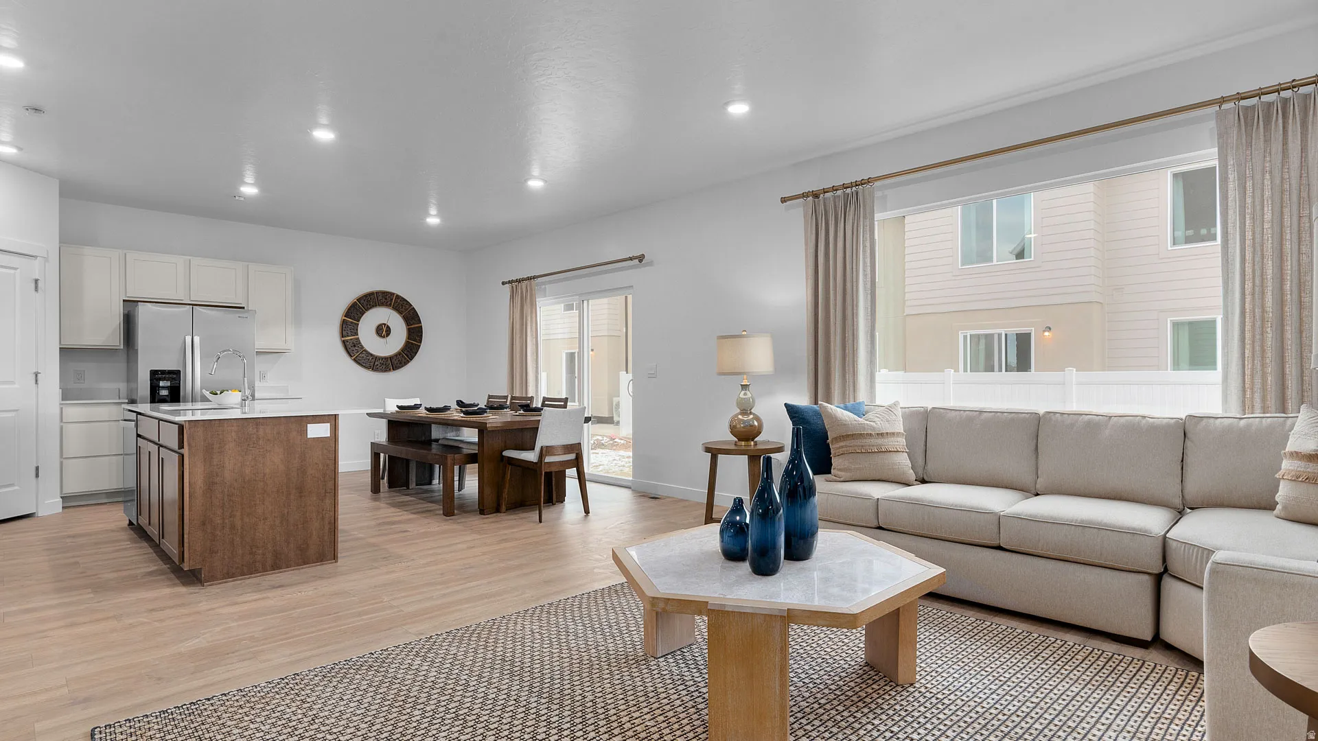 Open-concept living space featuring wood-finish flooring, recessed lighting, and a kitchen island with seating