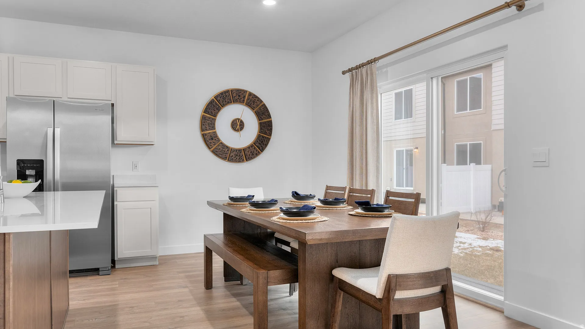 Open-concept living space with light wood-finish flooring, white walls, and recessed lighting