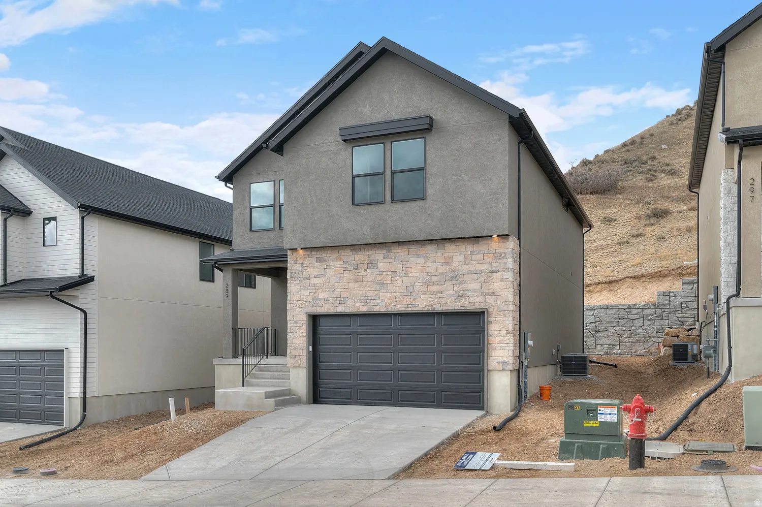 Modern exterior featuring a stucco finish with stone accents