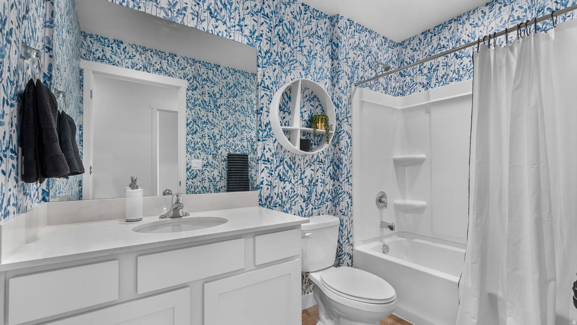 White vanity with a single basin sink, white quartz countertop, and chrome faucet