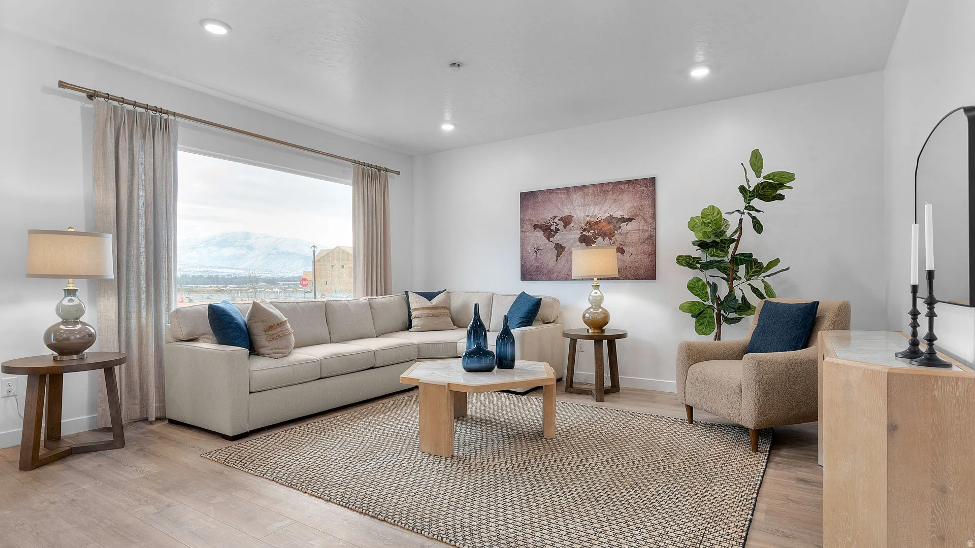 Spacious living area featuring wood-finish flooring, recessed lighting, and a large picture window